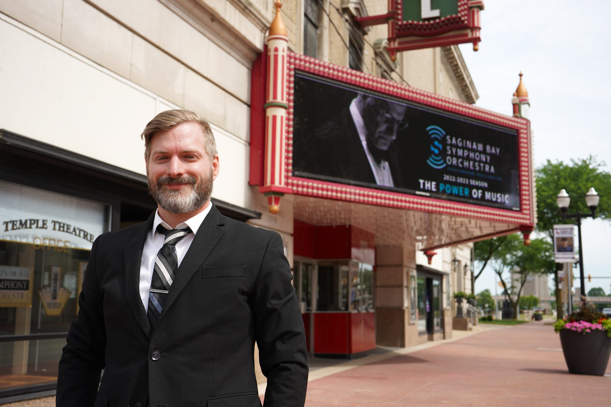 An Image of Cameron Massey in front of the Temple Theatre Marquee